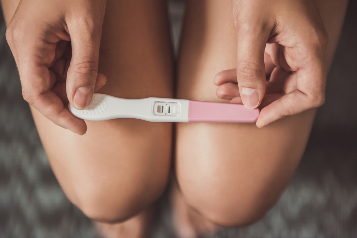 A woman holds a pregnancy test.