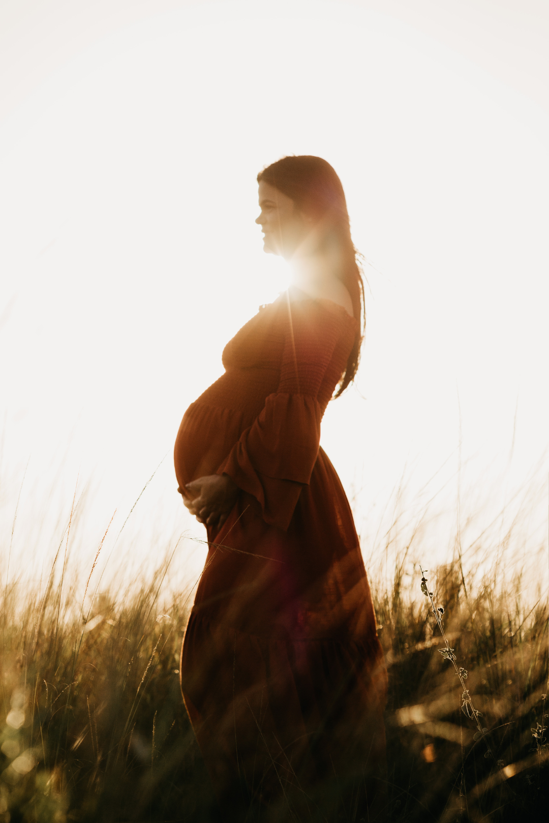 A pregnant women in a field smiles, illustrating the beauty of the Your Fertility Your Power message.